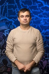 Portrait of a teacher in a beige sweater standing against a creative chalkboard background with a map and educational doodles. Perfect for themes of teaching, learning, or school environment