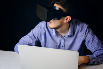 A person uses virtual reality on a laptop, blending technology with productivity and innovation in a modern workspace