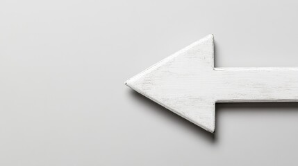 Obraz premium White Wooden Arrow Pointing Left on a Light Gray Background, Perfect for Directional Signage and Visual Guidance in Creative Projects and Designs