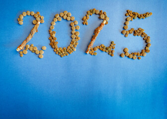 Background with the text 2025, text built from dry pet food. Graphic resources for pet shop promotion.