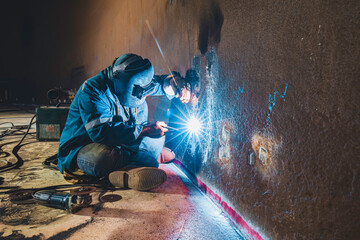 Welders at work in metal argon industry, welding metal plate tank construction close up wear...