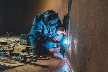 Welders at work in metal argon industry, welding metal plate tank construction close up wear...