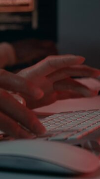 Vertical closeup of hands of anonymous multiethnic male and female IT specialists frantically typing commands on computer keyboards while fighting against hacker attack on corporate system