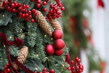 New Year background, Christmas tree branches with red balls and cones on blurred background