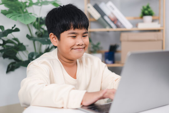 Educational of tech concept, Staying at home, Little Asian boy student using computer laptop learning, Presenting a modern educational way of life,, Virtual internet online class from school teacher.