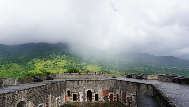 Rain falling over fort, the Brimstone Hill Fortress National Park, made of brick with green jungle and mountain in Saint Kitts
