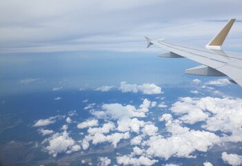 Airplane WingIn flight with clouds and landscape below