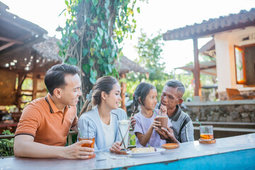 three generation asian family bonding by having lunch together in outdoor cafe