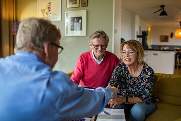 Senior couple talking to financial advisor at home