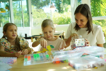 Teacher in workshop teched two girls how to assemble a thermo mosaic 