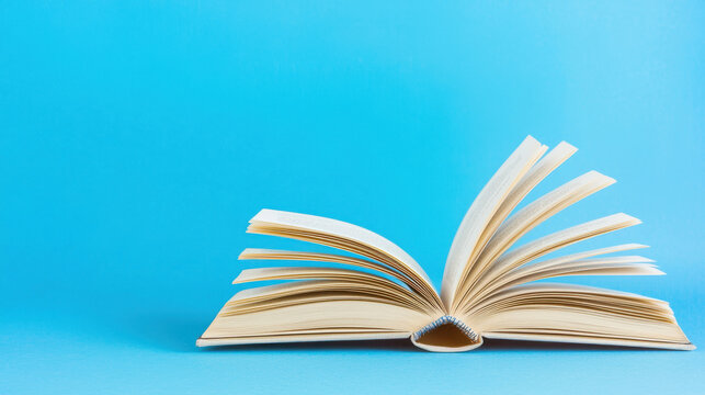 open book with pages turning against blue background, evoking sense of curiosity and imagination. vibrant blue enhances feeling of creativity and exploration
