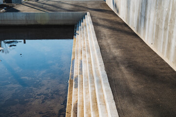 A beautifully designed concrete staircase descends into tranquil waters, creating an inviting...