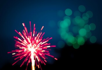 Fototapeta premium Red sparkler firework at night with bokeh lights