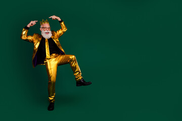 Charismatic bearded gentleman celebrates in elegant golden suit against green background