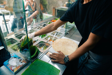 Chef making pita bread for falafel roll outdoor on street stall