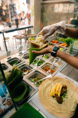 Chef making pita bread for falafel roll outdoor on street stall