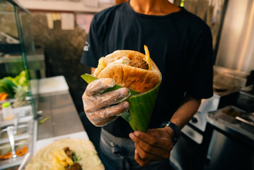 Chef making pita bread for falafel roll outdoor on street stall