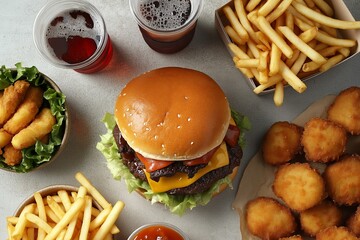 Fast food delivery menu background with various burgers, cheeseburger, nuggets, french fries, fizzy soda drinks. Top view