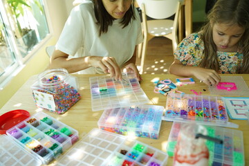Fototapeta premium Teacher in workshop teched two girls how to assemble a thermo mosaic 