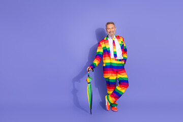 Obraz premium Full length photo of funky cool guy dressed lgbt rainbow costume rising parasol empty space isolated purple color background