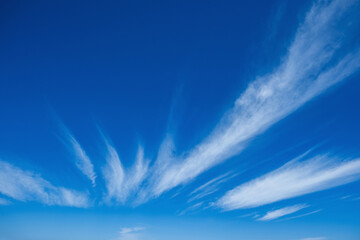 Clear blue sky with light, white clouds background.