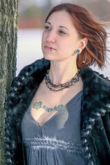Beautiful woman with tattoos in the snow