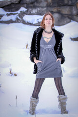 Beautiful woman in a dress standing in the snow