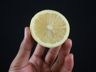 A man holds halves of a cut lemon in his hands. Exotic fruits in hands. Lemon close up