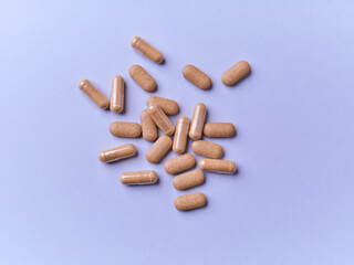 Ashwagandha (Withania somnifera) tablets and capsules on paper background. Soft focus.. Close up. Copy space.	