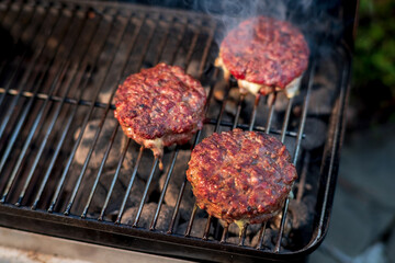 grilling hamburgers on barbecue grill,