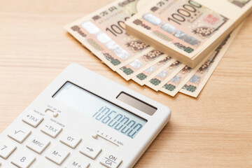 テーブルに置かれた106万円と電卓