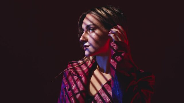 Portrait of attractive girl in a red leather jacket with healthy clean skin and beautiful make-up. Aesthetic cosmetology and makeup concept.