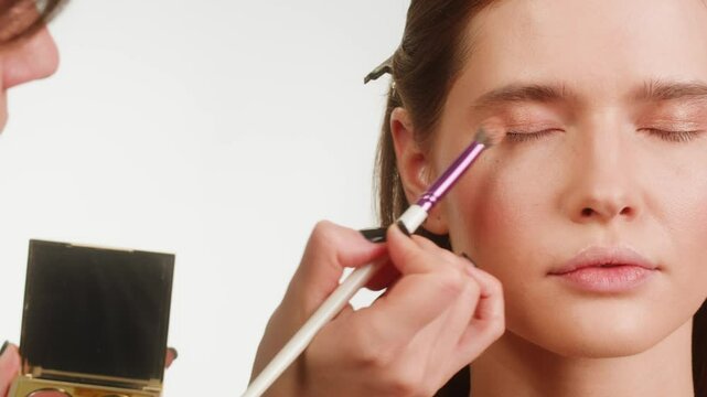 Beauty shot of woman makeup and hair artist doing hairstyle. Using hairspray for hair close-up.Concept of skincare, cosmetics, make up, beauty. Make-up and hair style tutorial 