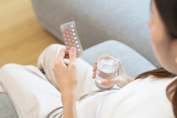 young female holding birth control pills