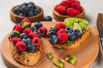 Sandwiches with chocolate paste, raspberries and blueberries