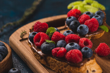 Sandwiches with chocolate paste, raspberries and blueberries