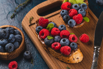 Sandwiches with chocolate paste, raspberries and blueberries