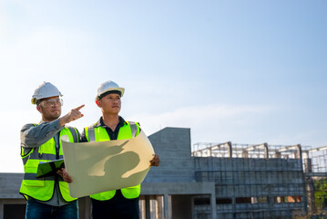 construction engineer Two officers are checking the progress of the building construction plan.