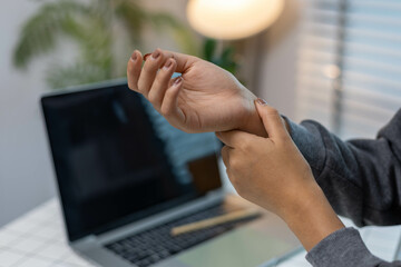 A female employee is suffering from office syndrome and is stretching to relax while working