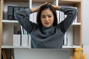 A female employee is suffering from office syndrome and is stretching to relax while working