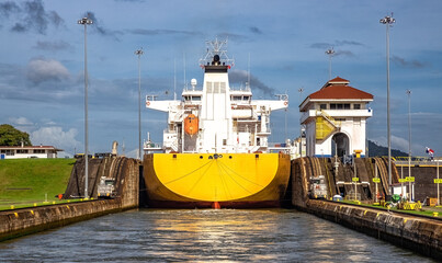 Ein gelbes Schiff wird in den Panamakanal eingeschleust.