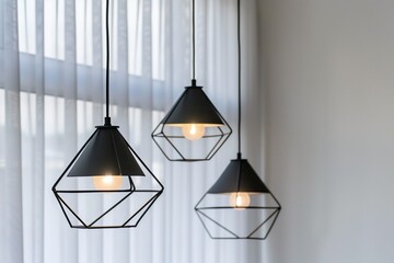 Modern minimalist black hanging lamps in the interior of a home or office, close-up.