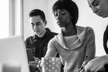 Multiracial business people working inside modern office - Focus on young black woman face - black and white editing