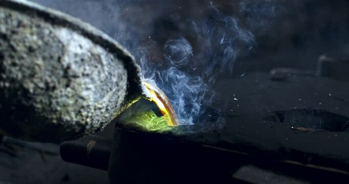 Super slow motion macro of brass melting in foundry at 1000 fps. Raw metal is heated in furnace until molten, then kept at  stable temperature for pouring