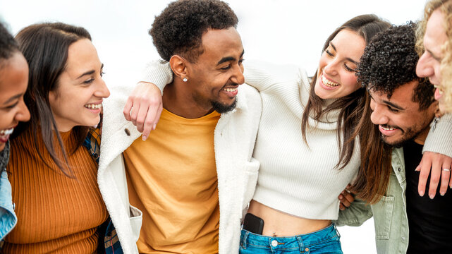 Happy multicultural people enjoying summer vacation outdoors - Smiling group of friends having fun walking outside - Friendship concept with guys and girls hanging out on a sunny day in spring