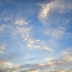 Fototapeta premium Expansive blue sky dotted with wispy white clouds.