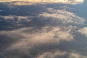 Fototapeta premium View of fluffy clouds against a blue sky captured during a flight at dusk highlighting the serene beauty of nature from above
