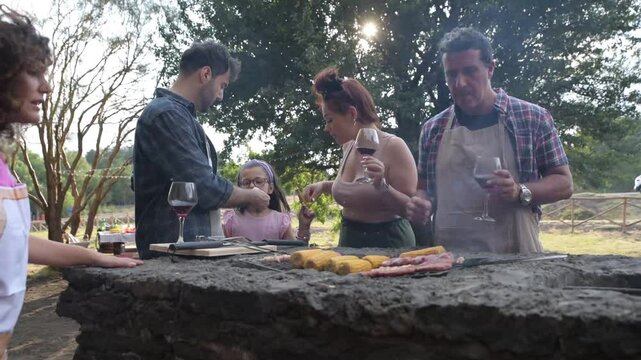 multi generation family grilling outside backyard in summer garden party &ndash; multigenerational family barbecuing on sunny summer day &ndash; happy multiracial people having fun barbecue grill