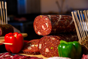 Sausages surrounded by diffferent meat products on a wooden table in a butcher shop. Shot of butchery manufactory table with meat goods.