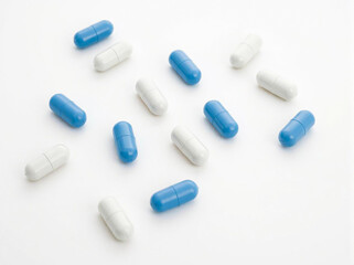 White and blue pills on a white background. Top view. Close-up. Medical  background.